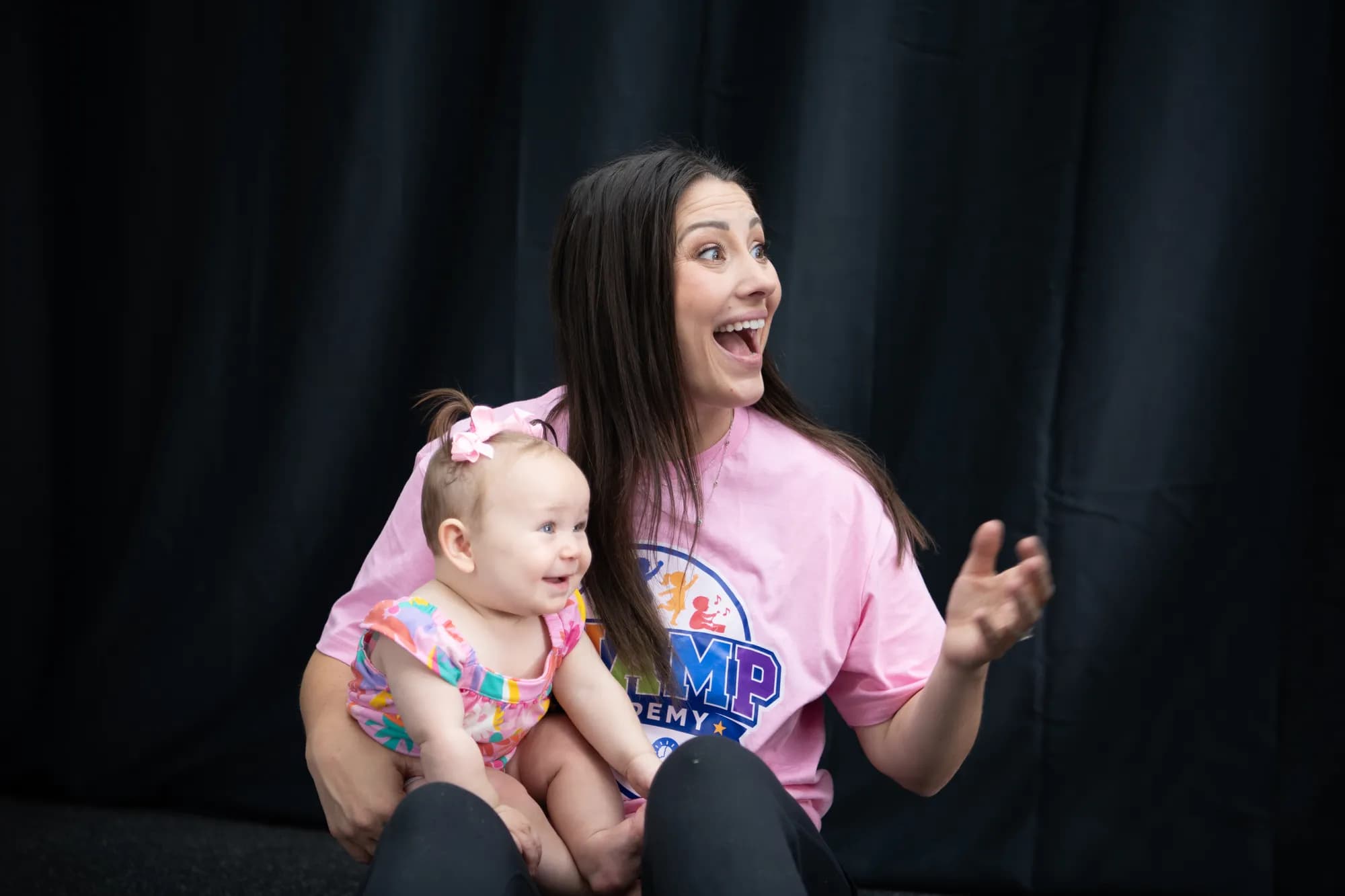 Alex, founder of CHAMP Academy, holding a baby at The Hitter's Edge