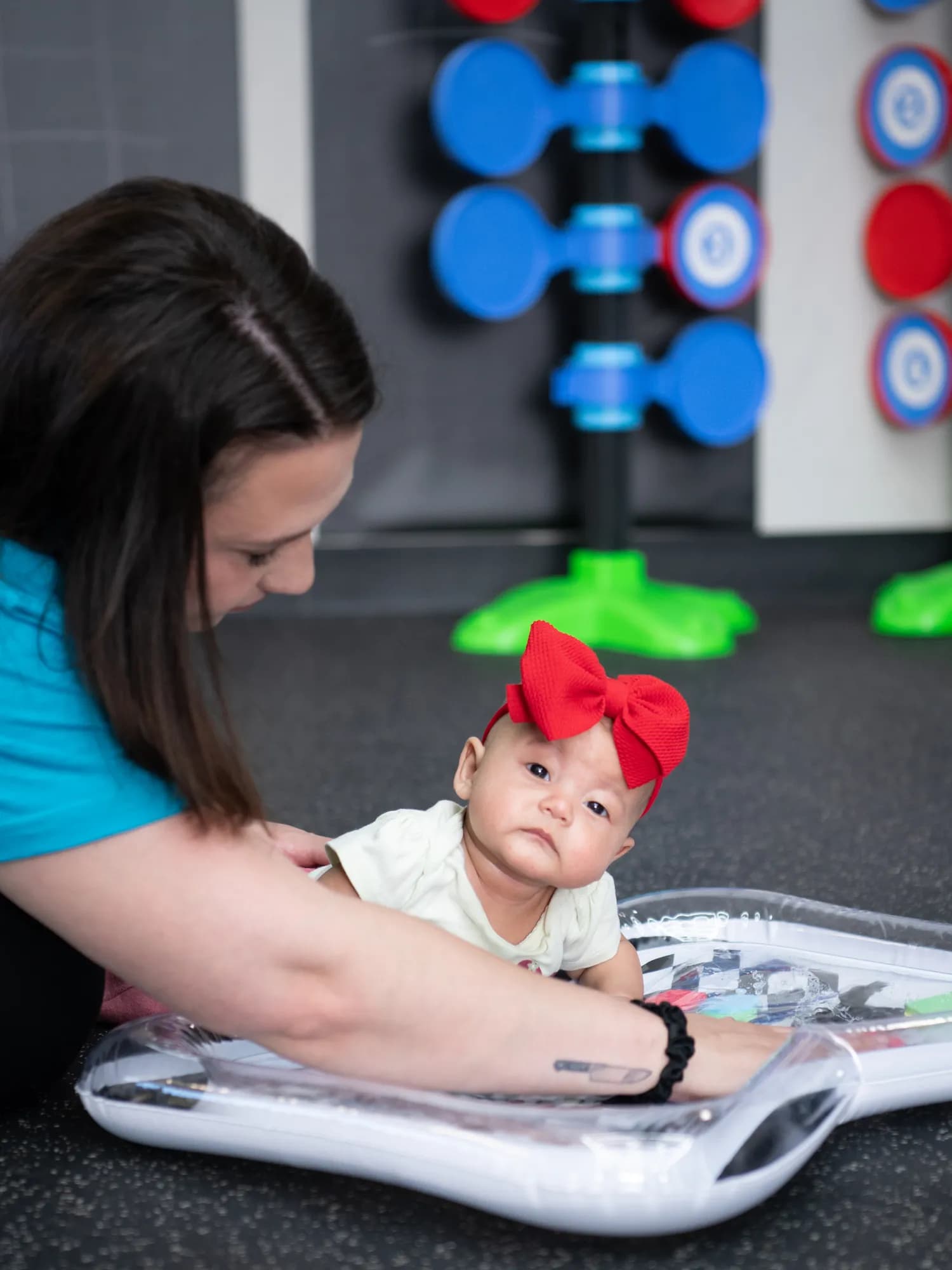 A baby exploring a water sensory mat during a Tiny Champs class
