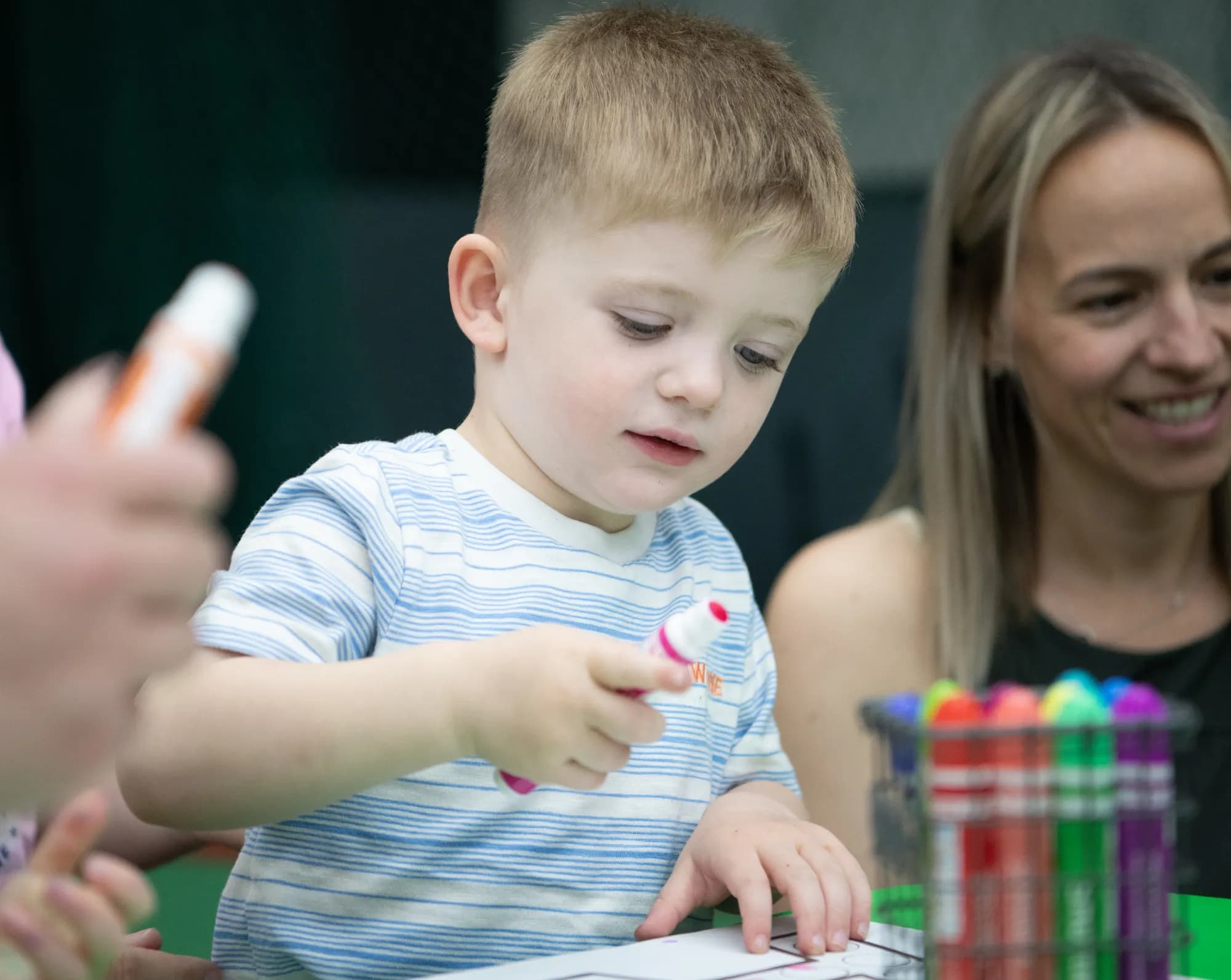 A young boy using a paint dauber during a CHAMP Academy art activity