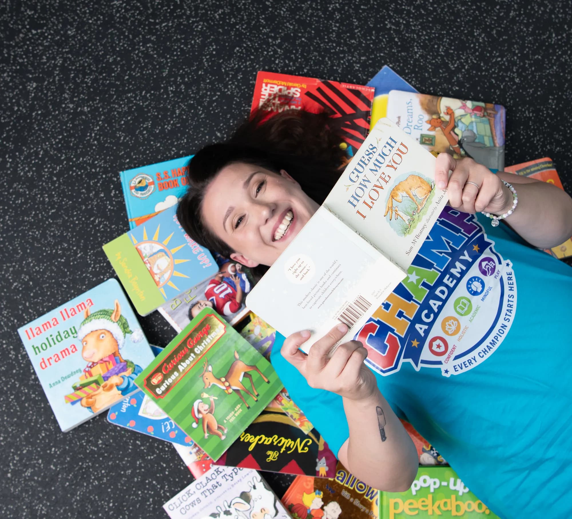 Meagan, Program Director at CHAMP Academy, surrounded by picture books
