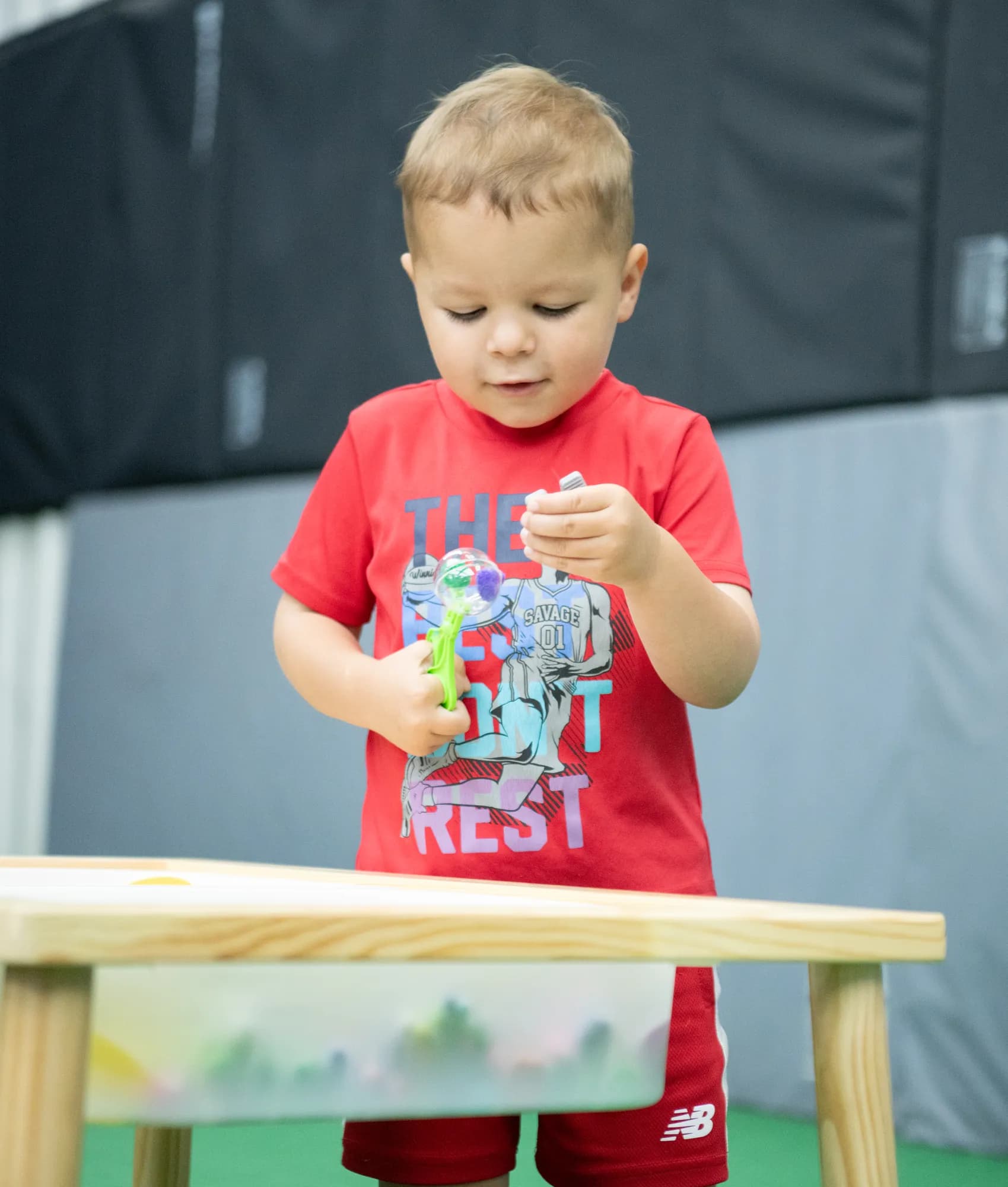 A young boy exploring a sensory table at a CHAMP Academy class